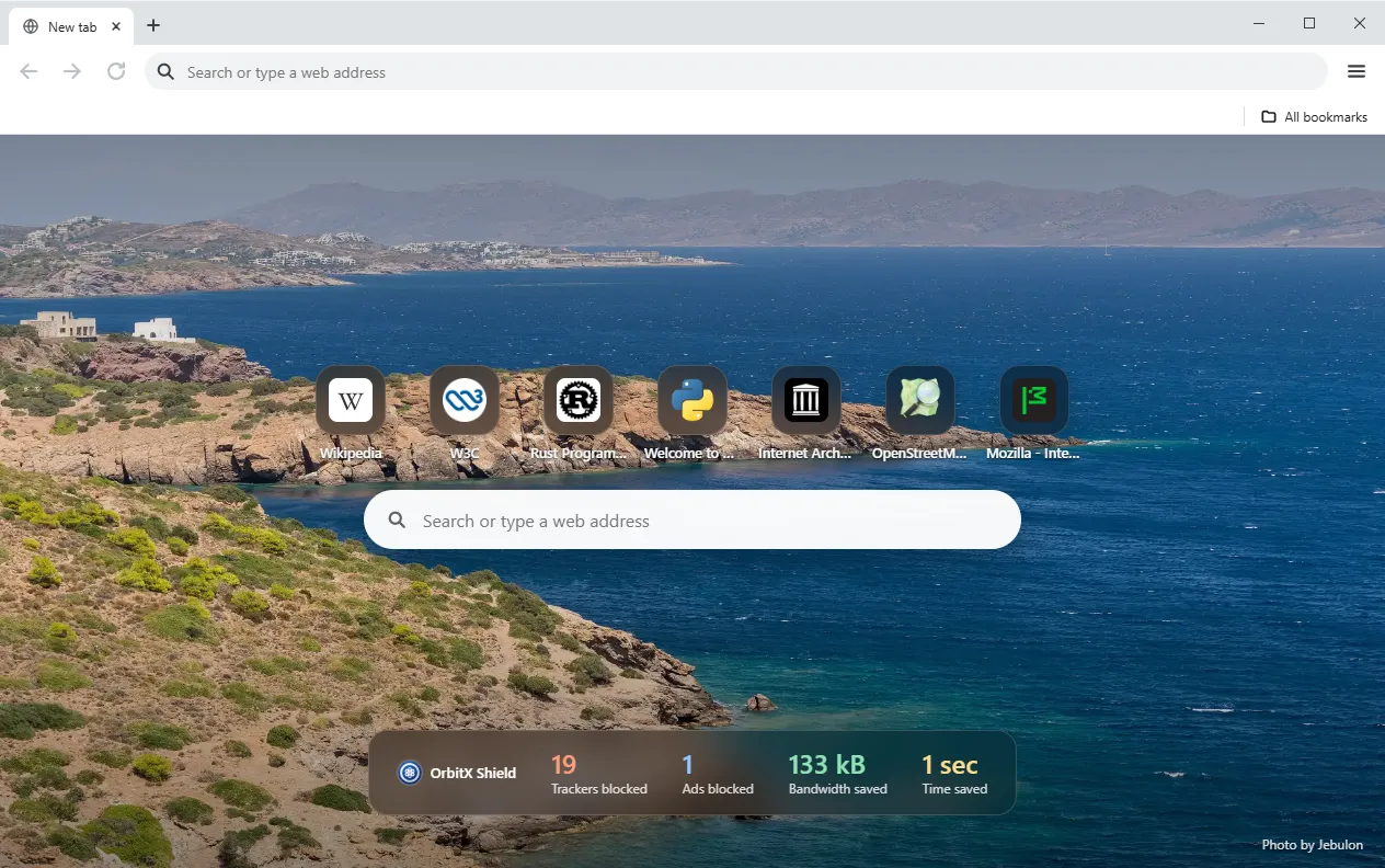 The OrbitX Browser window on its new tab page: a photo background, top sites, a search box and the OrbitX Shield counters for blocked trackers and ads.